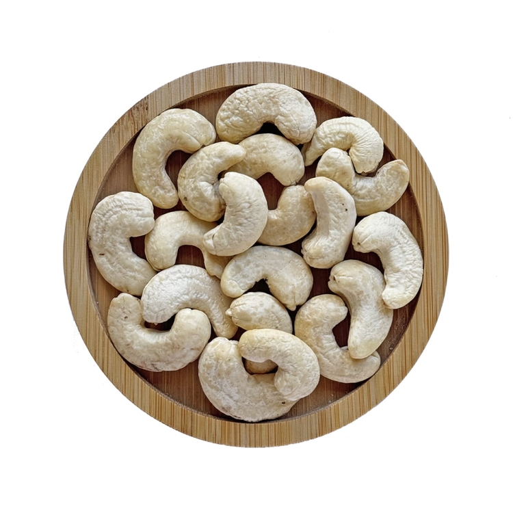 Orzechy nerkowca łuskane całe w drewnianej miseczce na białym tle